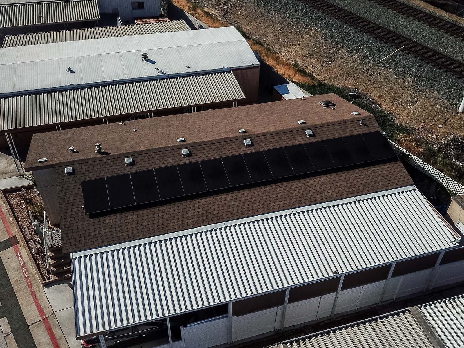 Aerial view of a manufactured home with solar panels installed on the roof, surrounded by other mobile homes, emphasizing solar energy solutions for mobile living.